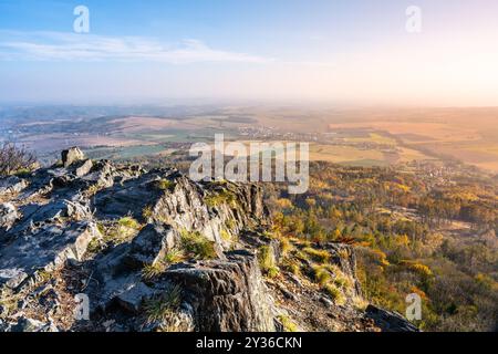 Par une journée d'automne ensoleillée, la montagne Sedlo offre une vue imprenable sur la campagne animée en contrebas, présentant une tapisserie de teintes dorées et vertes à travers les hautes terres de Bohême centrale. Banque D'Images