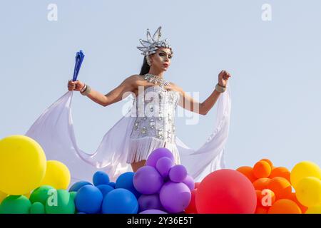 Goiânia GOIAS BRÉSIL - 08 SEPTEMBRE 2024 : une personne LGBT, vêtue de blanc avec un char décoré de ballons, danse, à la LGBT Pride Parad 2024 Banque D'Images