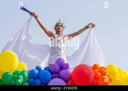 Goiânia GOIAS BRÉSIL - 08 SEPTEMBRE 2024 : une personne LGBT, vêtue de blanc avec un char décoré de ballons, danse, à la LGBT Pride Parad 2024 Banque D'Images