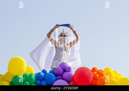 Goiânia GOIAS BRÉSIL - 08 SEPTEMBRE 2024 : une personne LGBT, vêtue de blanc avec un char décoré de ballons, danse, à la LGBT Pride Parad 2024 Banque D'Images