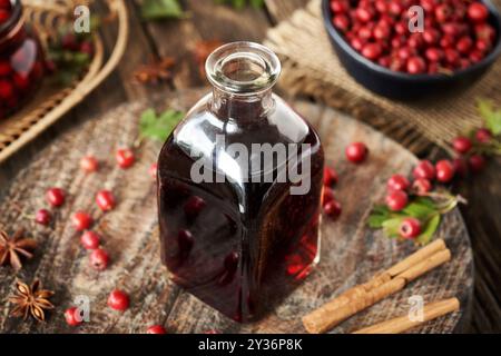 Une bouteille de vin rouge médicinal à base de baies d'aubépine fraîches et d'épices Banque D'Images