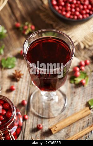 Une tasse de vin médicinal préparé à partir de baies d'aubépine fraîches et d'épices Banque D'Images