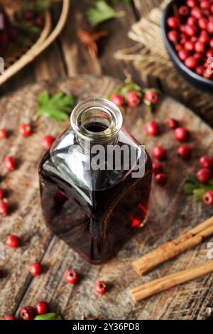 Une bouteille de vin médicinal préparée à partir de baies d'aubépine sauvages fraîches en automne Banque D'Images