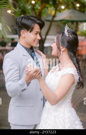 une paire d'homme et de femme élégantes pose debout dans un homme de rangée regardant leur femme danser sur une belle robe dans un parc photo shot. mariée nationale o Banque D'Images