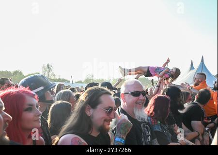 Sécurité transportez un jeune crowdsurfeur en toute sécurité au-dessus de la foule pendant le Bloodstock Open Air Heavy Metal Festival à Catton Hall le 11 août 2024 [Credit Graham Finney] avec : Atmosphere Where : Walton on Thames, Royaume-Uni quand : 11 août 2024 crédit : Graham Finney/WENN Banque D'Images