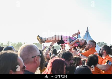 Sécurité transportez un jeune crowdsurfeur en toute sécurité au-dessus de la foule pendant le Bloodstock Open Air Heavy Metal Festival à Catton Hall le 11 août 2024 [Credit Graham Finney] avec : Atmosphere Where : Walton on Thames, Royaume-Uni quand : 11 août 2024 crédit : Graham Finney/WENN Banque D'Images