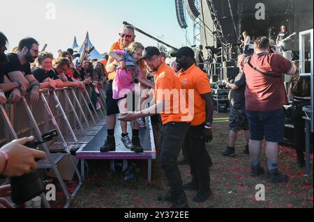 Sécurité transportez un jeune crowdsurfeur en toute sécurité au-dessus de la foule pendant le Bloodstock Open Air Heavy Metal Festival à Catton Hall le 11 août 2024 [Credit Graham Finney] avec : Atmosphere Where : Walton on Thames, Royaume-Uni quand : 11 août 2024 crédit : Graham Finney/WENN Banque D'Images