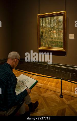 Londres, Angleterre - 21-05-05 2024 : un homme étudie une peinture de Pisarro à la National Gallery de Londres, Angleterre Banque D'Images