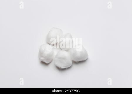 Boules de coton blanc pelucheux sur fond blanc Banque D'Images
