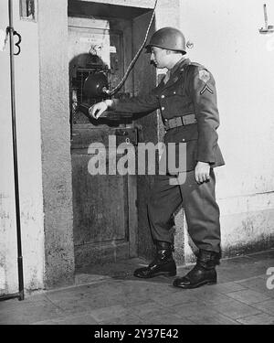 Un soldat américain gardant la porte de la cellule de Rudolf Hess au procès de Nuremberg. Les procès de Nuremberg étaient une série de procès de dirigeants militaires et politiques nazis. Les procès ont eu lieu de 1945 à 1949. Le premier a été le Tribunal militaire international qui a jugé les grands noms comme Göring, Ribbentrop, Keitel, etc Il y a eu par la suite 12 procès de groupes d'hommes comprenant des médecins, les Einsatzgruppen et le haut commandement militaire. Banque D'Images