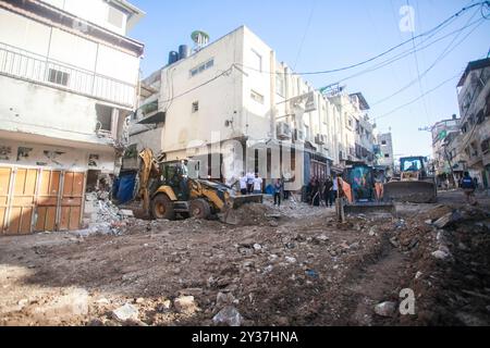 Tulakrm, Palestine. 12 septembre 2024. Des bulldozers palestiniens améliorent la rue détruite à la suite d'un raid de l'armée israélienne à Tulkarem et dans ses camps dans le nord de la Cisjordanie occupée. Le ministre israélien de la Défense Yoav Gallant a déclaré le 11 septembre que l'armée devrait utiliser toute sa « force » pour frapper les militants palestiniens en Cisjordanie occupée, où une opération militaire de grande envergure a tué des dizaines de personnes. Crédit : SOPA images Limited/Alamy Live News Banque D'Images