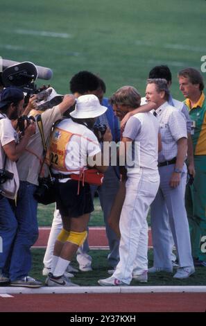 20 août 1984 ; Los Angeles, CA, États-Unis ; lors de la finale olympique de 1984, lors du 3 000 mètres, MARY DECKER s'est mêlée à Zola Budd, une originaire d'Afrique du Sud qui courait pour la Grande-Bretagne. Decker trébucha, tomba sur le champ et se blessa à la hanche. Photo : DECKER s'arrête du champ, entouré par la presse. Credit : Arthur Grace/ZUMAPRESS.com/Alamy Live News Banque D'Images