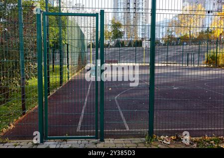 Porte d'entrée du terrain de basket-ball dans le parc de la ville à Kiev, Ukraine. Clôture en fil métallique. Porte d'entrée en métal vert Banque D'Images