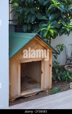 Maison de chien en bois nichée à côté d'une végétation luxuriante dans un cadre paisible de cour arrière Banque D'Images