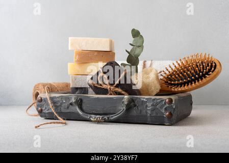 Un ensemble de salle de bains magnifiquement agencé avec des savons faits à la main, une brosse à cheveux en bois et un loofah. Idéal pour les soins naturels de la peau, les routines de bien-être et l'éco Banque D'Images