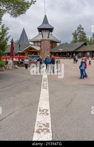 Rovaniemi, Finlande - 07.2024 : touristes à la traversée du cercle arctique dans le village du Père Noël en été Banque D'Images