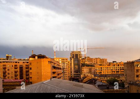 Ciel nuageux du soir au-dessus de la zone résidentielle dans la ville d'Erevan Arménie sur le coucher du soleil orange Banque D'Images