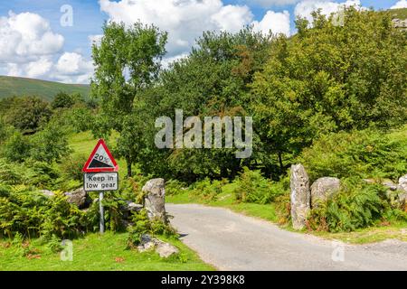 Une pente raide et garder en bas signe de vitesse sur une voie de campagne sur Bonehill Dartmoor National Park, Devon, Angleterre. Banque D'Images