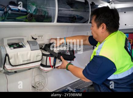 Chiang mai, Thaïlande. 13 septembre 2024. Un responsable des secours de la municipalité de Chiang mai prépare l'équipement dans l'ambulance avant de se rendre pour venir en aide aux victimes des inondations dans le district de Mae ai, Chiang mai, Thaïlande. Pour résoudre le problème des inondations dans le district de Mae ai, la municipalité de Chiang mai a déployé du personnel et du matériel, y compris des véhicules de sauvetage, des bateaux à fond plat, des citernes, des grues, excavatrices, camions et ambulances, pour aider les victimes des inondations. L'opération devrait prendre environ 5 jours. Crédit : SOPA images Limited/Alamy Live News Banque D'Images