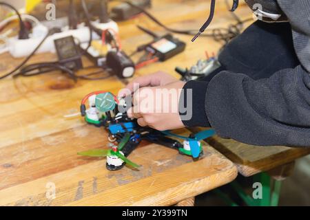 Un homme assemble et configure un drone à grande vitesse. Drone FPV Banque D'Images