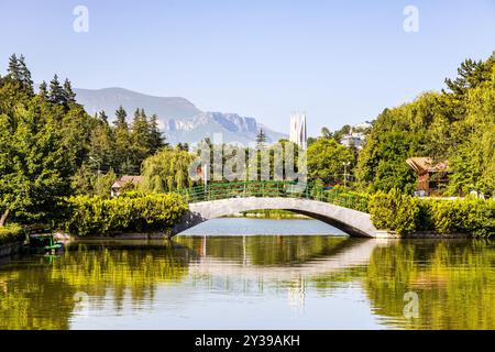 Pont piétonnier sur l'étang artificiel de la ville de lac dans la ville de Dilijan le jour ensoleillé d'été Banque D'Images