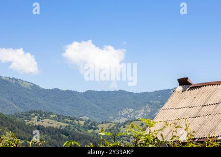 Ciel bleu avec des nuages blancs sur les montagnes entourant la ville de Dilijan le matin ensoleillé d'été Banque D'Images