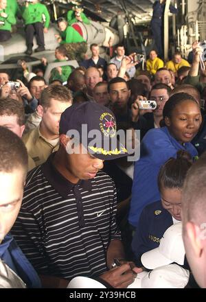 Golfe Arabique (mars 3, 2004) - le golfeur professionnel Tiger Woods signe des casquettes pour l'équipage à bord du porte-avions à propulsion nucléaire USS George Washington (CVN 73) après une démonstration de conduite de balle de golf. Banque D'Images