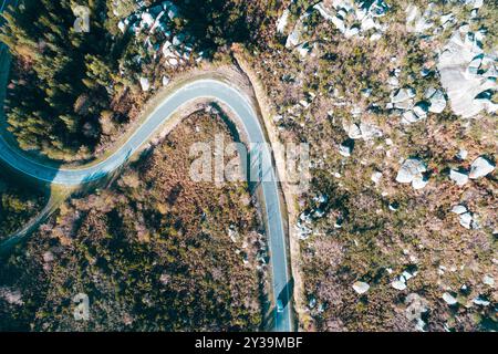 une voiture conduisant sur une route de montagne sinueuse, vue aérienne de dessus avec drone Banque D'Images