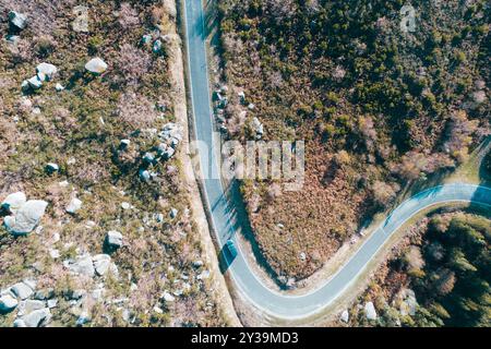 une voiture roulant sur une route de montagne sinueuse, vue aérienne avec drone Banque D'Images