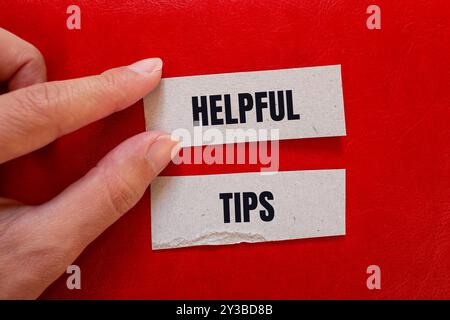 Conseils utiles message écrit sur des morceaux de papier avec fond rouge. Symbole astuces conceptuelles utiles. Copier l'espace. Banque D'Images