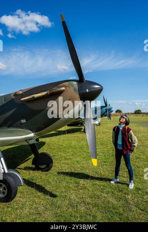 Duxford, Royaume-Uni. 13 septembre 2024. Un visiteur voit le Spitfire N3200, qui a été restauré dans ses spécifications d'origine pour commémorer le 75e anniversaire de la bataille d'Angleterre, par l'entrepreneur américain Thomas Kaplan. Il le rendit ensuite à Duxford en cadeau qui fut reçu au nom du Musée par le prince William en 2015. Préparation pour le spectacle aérien de la bataille d'Angleterre à l'IWM Duxford. Crédit : Guy Bell/Alamy Live News Banque D'Images