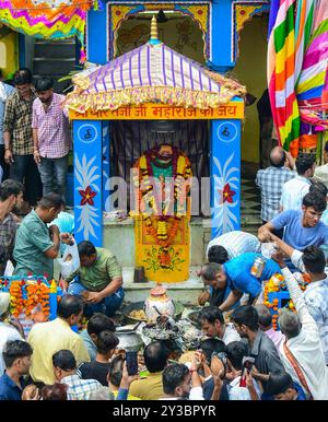 Beawar, Rajasthan, Inde, 13 septembre 2024 : des dévots hindous se rassemblent pour offrir des prières dans un temple pendant les célébrations du festival Teja Dashami à Beawar. Ils offrent des drapeaux religieux colorés et guirlande à la divinité folklorique Teja et dansent sur des rythmes de dhol. Veer Teja est considéré comme l'une des onze principales incarnations du Seigneur Shiva et vénéré comme une divinité dans le Rajasthan rural. Crédit : Sumit Saraswat/Alamy Live News Banque D'Images