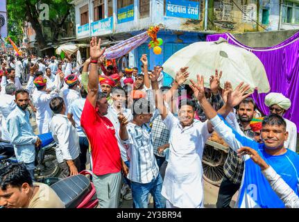 Beawar, Rajasthan, Inde, 13 septembre 2024 : des milliers de dévots hindous se rassemblent pour offrir des prières dans un temple pendant les célébrations du festival Teja Dashami à Beawar. Ils offrent des drapeaux religieux colorés et guirlande à la divinité folklorique Teja et dansent sur des rythmes de dhol. Veer Teja est considéré comme l'une des onze principales incarnations du Seigneur Shiva et vénéré comme une divinité dans le Rajasthan rural. Crédit : Sumit Saraswat/Alamy Live News Banque D'Images