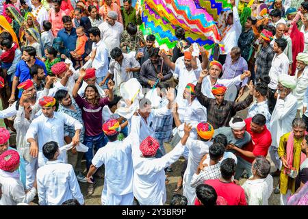 Beawar, Rajasthan, Inde, 13 septembre 2024 : des milliers de dévots hindous se rassemblent pour offrir des prières dans un temple pendant les célébrations du festival Teja Dashami à Beawar. Ils offrent des drapeaux religieux colorés et guirlande à la divinité folklorique Teja et dansent sur des rythmes de dhol. Veer Teja est considéré comme l'une des onze principales incarnations du Seigneur Shiva et vénéré comme une divinité dans le Rajasthan rural. Crédit : Sumit Saraswat/Alamy Live News Banque D'Images