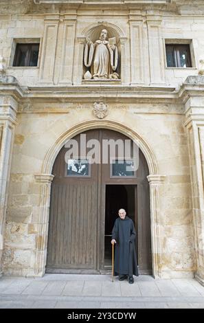 Moine bénédictin, 92 ans, au portail de l'église abbatiale ou monastère de Santo Domingo de silos, province de Burgos, Castille-et-Léon, Espagne Banque D'Images