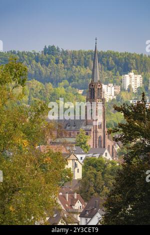 Une tour d'église frappante s'élève d'un village boisé de maisons, entouré par la nature et sous un ciel clair, Nagold, Forêt Noire, Allemagne, Europe Banque D'Images