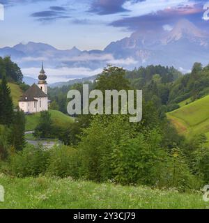 Église Maria Gern dans un paysage de montagne pittoresque, entouré d'une végétation verte dense et de collines ondulantes dans la brume du matin, Berchtesgaden, Bava Banque D'Images