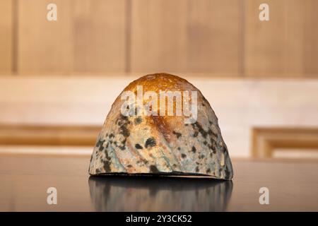 Pain coupé rassis, gâté et moisi sur une table de cuisine. Gros plan, faible profondeur de champ, personne. Banque D'Images