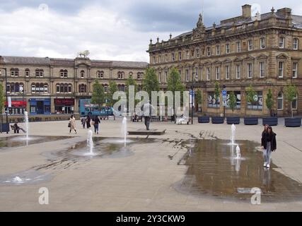 Huddersfield, yest yorkshire, Royaume-Uni, 20 mai 2019 : les gens marchent sur la place St georges à Huddersfield entre les fontaines d'eau et surroun Banque D'Images