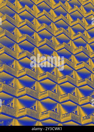 Une image abstraite en duotone jaune et bleue d'un grand immeuble résidentiel de grande hauteur avec des rangées géométriques de balcons Banque D'Images