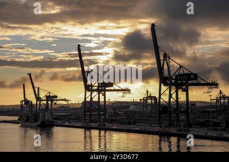 Port industriel avec de grandes grues au premier plan et un coucher de soleil spectaculaire sur l'eau, Gothenburg, mer Baltique, Suède, Europe Banque D'Images