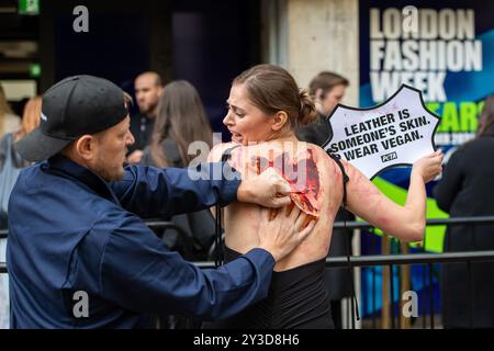 Londres, Angleterre, Royaume-Uni. 13 septembre 2024. Les supporters de PETA protestent contre l'utilisation du cuir en simulant l'expérience douloureuse d'être « écorché vivant » devant l'espace de spectacle NEWGEN du British Fashion Council pendant la Fashion week de Londres. La manifestation vise à sensibiliser aux souffrances causées par l’industrie du cuir et à promouvoir des alternatives durables et végétaliennes. (Crédit image : © Thomas Krych/ZUMA Press Wire) USAGE ÉDITORIAL SEULEMENT! Non destiné à UN USAGE commercial ! Banque D'Images