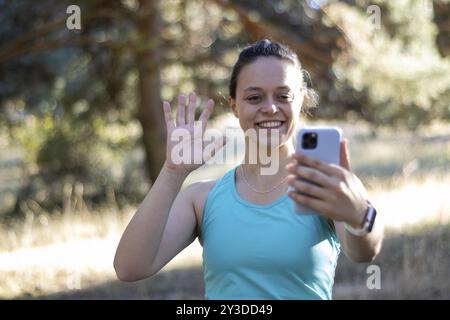 Femme souriante parlant sur appel vidéo avec téléphone portable, gros plan horizontal Banque D'Images