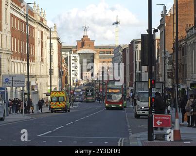 Leeds, yorkshire de l'Ouest, Royaume-uni, 17 mars 2022 : trafic de bus et personnes sur la tête à leeds avec la maison de carrière au bas de la route Banque D'Images