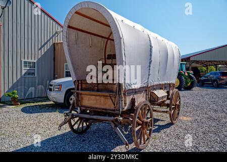 Un chariot à dos restauré authentique en bois avec une nouvelle bâche en toile enveloppant le wagon avant et vue latérale en gros plan garé dans une ferme par une journée ensoleillée en été Banque D'Images