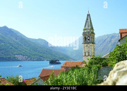 Paysage de Perast, Monténégro : clocher de l'église de équipés Nicholas, toits de tuiles et la mer avec des bateaux naviguant vers l'île de équipés George Banque D'Images