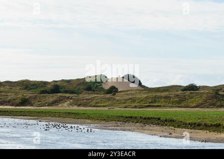 Deux personnes se tiennent au sommet de la Big Dipper, la plus haute dune de sable de la réserve naturelle de Methyr Mawr, Ogmore by Sea, Vale of Glamorgan, pays de Galles du Sud. Banque D'Images