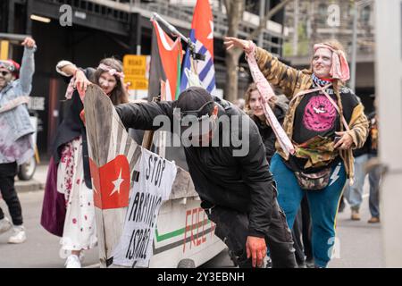 Melbourne, Australie. 13 septembre 2024. Des manifestants habillés en zombies ont vu pousser un bateau avec des pancartes et des drapeaux dessus pendant le rallye. Pour le dernier jour de Land Forces, une exposition sur les armes, les manifestants se déguisaient en zombies et se savouraient de faux sang. Ils ont mis des chaussures d'enfants devant les lignes de police pour représenter les enfants palestiniens tués. Pendant la manifestation, les manifestants soufflent également des bulles en criant à la police "vous n'avez pas d'amis, nous avons des bulles". Crédit : SOPA images Limited/Alamy Live News Banque D'Images