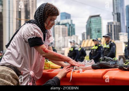 Melbourne, Australie. 13 septembre 2024. Les manifestants placent des chaussures d'enfants devant les lignes de police pour représenter les enfants palestiniens tués pendant le rassemblement. Pour le dernier jour de Land Forces, une exposition sur les armes, les manifestants se déguisaient en zombies et se savouraient de faux sang. Ils ont mis des chaussures d'enfants devant les lignes de police pour représenter les enfants palestiniens tués. Pendant la manifestation, les manifestants soufflent également des bulles en criant à la police "vous n'avez pas d'amis, nous avons des bulles". Crédit : SOPA images Limited/Alamy Live News Banque D'Images