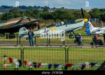 Duxford, Royaume-Uni. 13 septembre 2024. Un Hispano HA-112 Mil Buchón “Yellow 10” sur la ligne de vol surveillé par des observateurs d’avions - préparation pour le Battle of Britain Air Show à IWM Duxford. Crédit : Guy Bell/Alamy Live News Banque D'Images